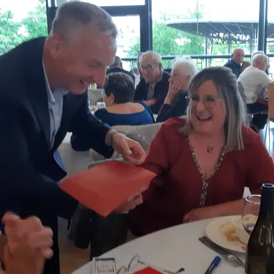 Francis Darcy en close-up avec une spectatrice souriante lors d'un repas