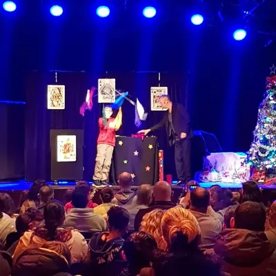 Francis montre un tour de cartes à un groupe d'enfants